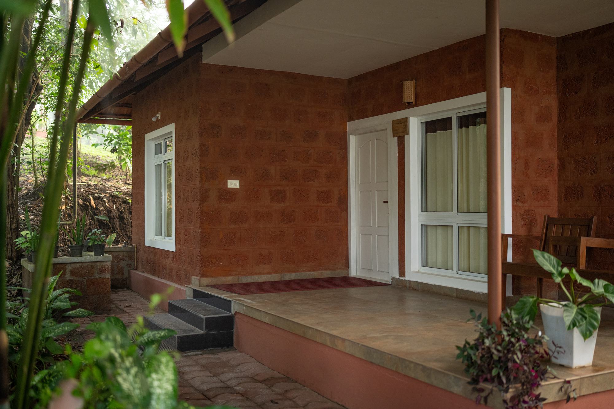 Deluxe suite cottage with laterite walls and a shaded veranda
