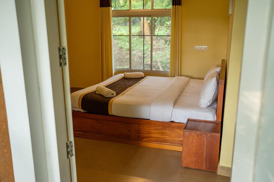 Cottage bedroom with a double bed and a window onto the trees