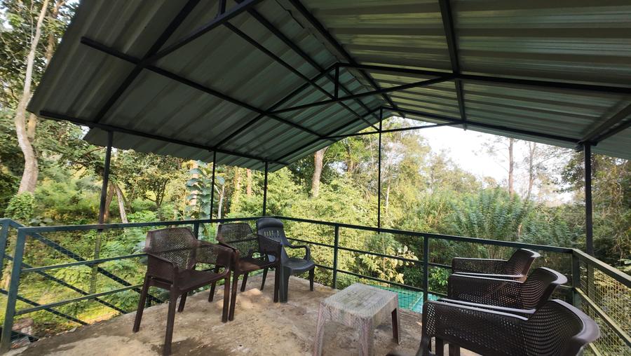 Covered watch tower deck with chairs, looking into the forest